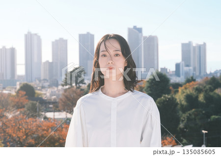 都会の街並みと若い女性 135085605