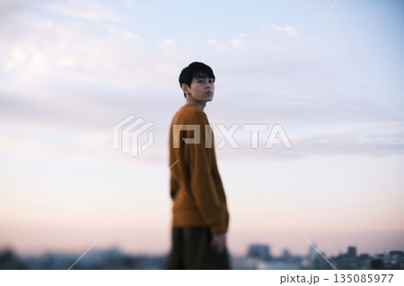 夕暮れ 屋上にいる男性のポートレート 135085977