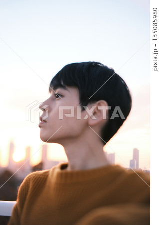夕暮れ 屋上にいる男性のポートレート 135085980