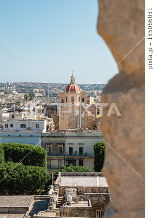 A breathtaking panoramic view of Gozo Island, showcasing its rolling hills, historic architecture, and stunning coastline under the Mediterranean sun. A breathtaking panoramic view of Gozo Island, showcasing its rolling hills, historic architecture, and stunning coastline under the Mediterranean sun. 135086031