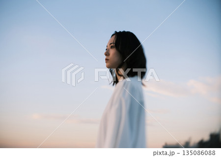 夕暮れ 若い女性のポートレート 135086088