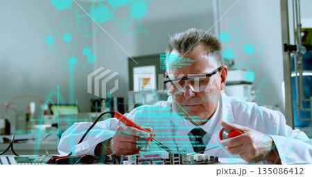 Senior scientist in lab coat testing circuit board at lab, with red black probes, digital overlays 135086412