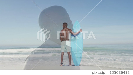 Holding light blue surfboard, surfer wearing green boardshorts on ocean shore, with suit silhouette Holding light blue surfboard, surfer wearing green boardshorts on ocean shore, with suit silhouette 135086452
