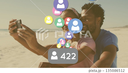 Taking selfie Black couple hugging at beach edge, with smartphone, floating avatars and 422 badge Taking selfie Black couple hugging at beach edge, with smartphone, floating avatars and 422 badge 135086512