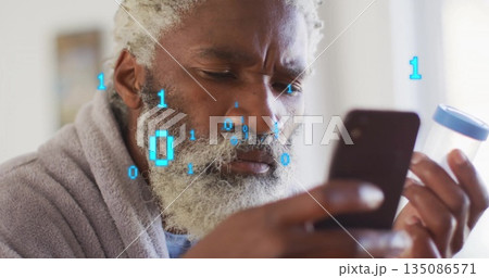 Standing man in bathrobe holding smartphone and pill bottle by bedroom window, with binary overlay Standing man in bathrobe holding smartphone and pill bottle by bedroom window, with binary overlay 135086571
