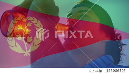 Raising brown bottle to lips, man wearing backward cap striped shirt under Eritrean flag overlay Raising brown bottle to lips, man wearing backward cap striped shirt under Eritrean flag overlay 135086595