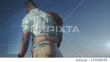 Standing couple holding waists at water's edge, with botanical shirt white dress and digital lines 135086636