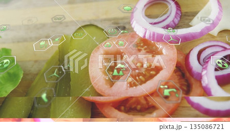 Displaying lettuce, pickles, tomatoes and onions lining chopping board in kitchen with eco icons 135086721