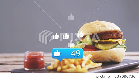 Highlighting cheeseburger on board in studio with fries and ketchup, thumbs-up bubble, copy space Highlighting cheeseburger on board in studio with fries and ketchup, thumbs-up bubble, copy space 135086736