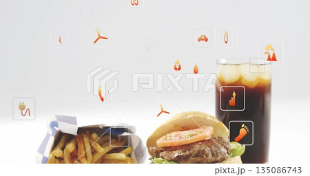 Presenting fast-food items resting on white tabletop, with fries burger soda and metric icons 135086743