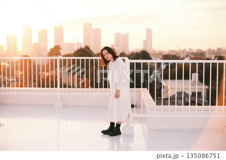 夕暮れ 屋上にいる女性のポートレート 135086751