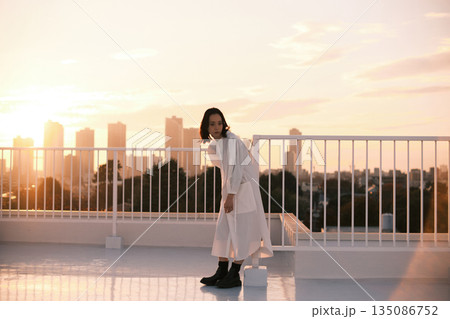 夕暮れ 屋上にいる女性のポートレート 夕暮れ 屋上にいる女性のポートレート 135086752