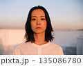 夕暮れ 屋上にいる女性のポートレート 135086780