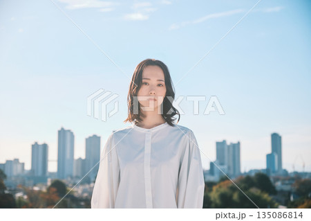 都会の街並みと若い女性 135086814