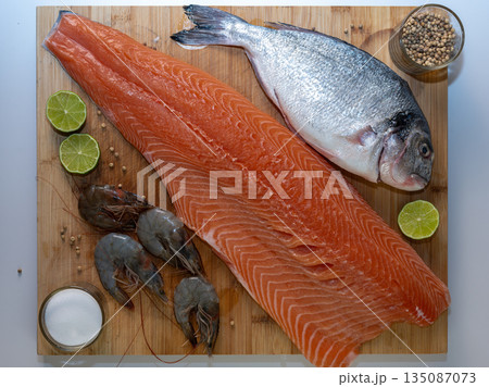 Healthy seafood assortment featuring fresh salmon, dorado, and shrimps. Clean, nutritious food concept with natural ingredients rich in protein and omega-3. 135087073
