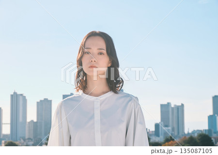 都会の街並みと若い女性 都会の街並みと若い女性 135087105