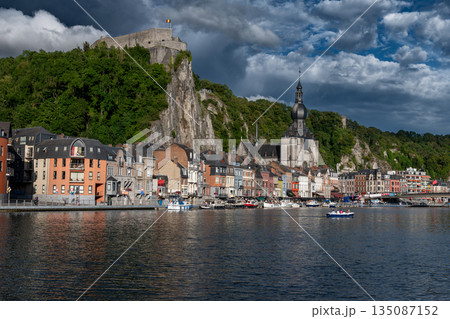 Scenic view of Dinant, Belgium, featuring historic riverside buildings and the citadel perched above the Meuse River. 135087152