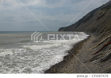 Panoramic view of the sea from a rocky hillside with pine trees under a clear blue summer sky Panoramic view of the sea from a rocky hillside with pine trees under a clear blue summer sky 135087478