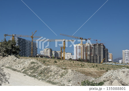 August 24, 2025: New residential district under construction in Novorossiysk, Russia, with unfinished monolithic apartment buildings and tower cranes against the sky 135088801