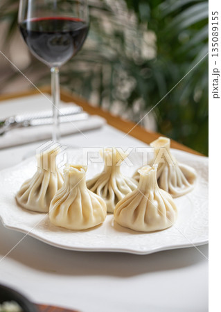 Traditional steamed khinkali dumplings on plate Traditional steamed khinkali dumplings on plate 135089155