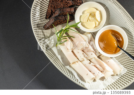 Traditional Ukrainian appetizer with lard, rye bread, garlic, and mustard sauce on a gray plate. top view. copy space Traditional Ukrainian appetizer with lard, rye bread, garlic, and mustard sauce on a gray plate. top view. copy space 135089393