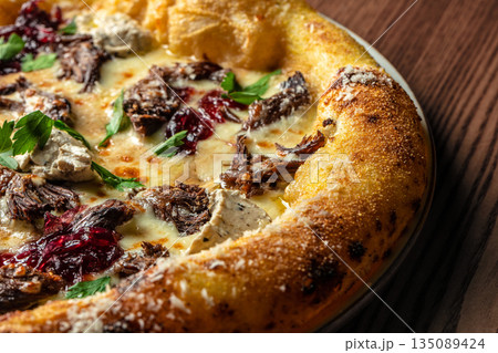 Gourmet pizza with slow-cooked beef, cream cheese, herbs, and berry sauce on a golden crust Gourmet pizza with slow-cooked beef, cream cheese, herbs, and berry sauce on a golden crust 135089424