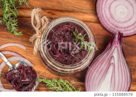 Homemade caramelized red onions in a glass jar with fresh thyme on wooden background Homemade caramelized red onions in a glass jar with fresh thyme on wooden background 135089579