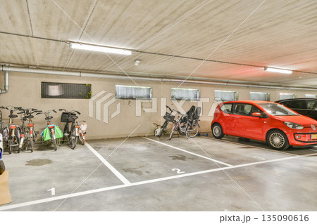 A well-organized urban parking area featuring several bicycles along with parked cars, showcasing efficient use of space in a commercial setting. 135090616