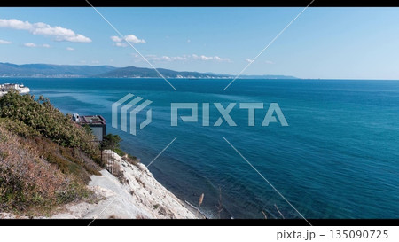 View of Tsemesskaya Bay from Mount Koldun in Myskhako near Novorossiysk, Russia, overlooking the Black Sea coastline, port area and mountainous landscape 135090725