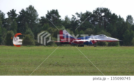 25 July 2021, Russia, Zhukovsky. Russian aerobatic team Swifts flying MiG-29 jets lands with drag chutes deployed at MAKS 2021 air show, demonstrating precision flying and military aviation. 135090745