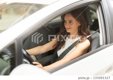 Young woman drives car in city 135091327