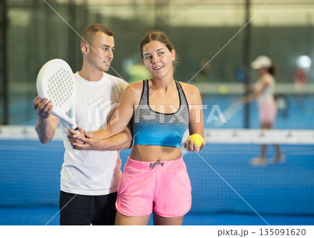 Young girl learns to play padel under guidance of male coach Young girl learns to play padel under guidance of male coach 135091620