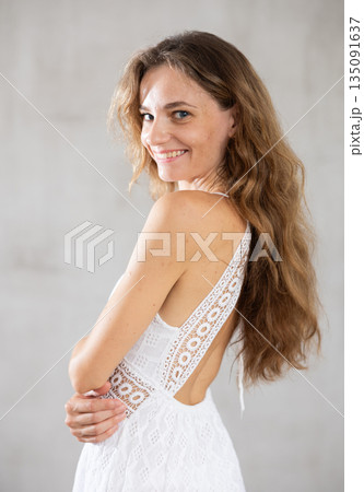 Young smiling woman posing against wall background 135091637