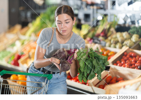 Young girl purchaser buying beetroots in grocery store 135091663