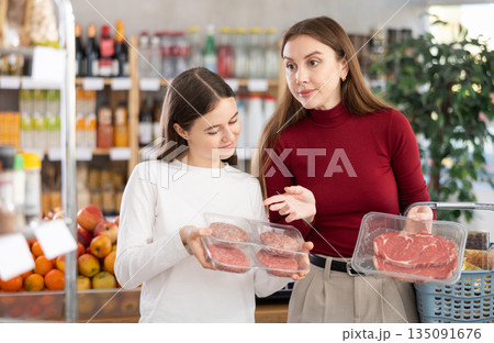 Mother and child choose cutlets and meat 135091676