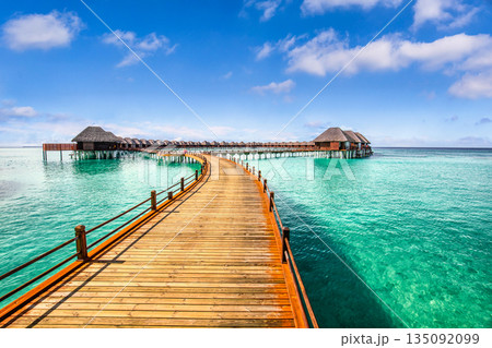 Panoramic Maldives beach landscape with luxury water villa resort wooden pier or jetty tropical panorama turquoise lagoon summer vacation travel tourism exotic island getaway background scenic holiday 135092099