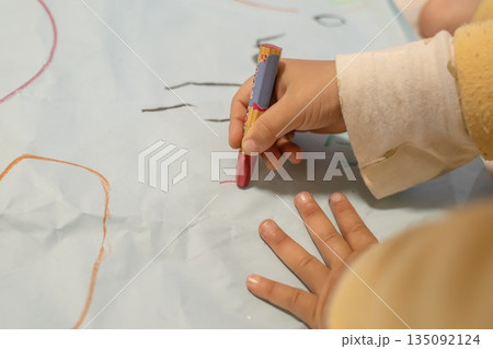 赤いクレヨンで紙に絵を描く手 135092124