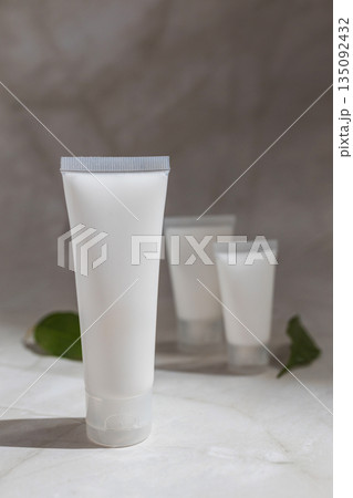 Minimalist skincare mockup with blank cosmetic tubes and green leaves on marble surface, ideal for natural beauty products, organic branding, clean cosmetics and modern wellness design. Minimalist skincare mockup with blank cosmetic tubes and green leaves on marble surface, ideal for natural beauty products, organic branding, clean cosmetics and modern wellness design. 135092432