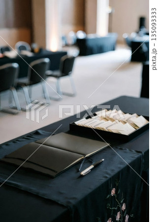 葬儀会場の受付に用意された芳名帳と筆記用具 135093333