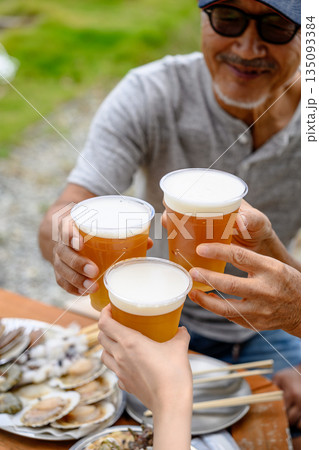 屋外でビール乾杯と牡蠣 【撮影協力:隠岐シーサイドリゾートみやび様】 屋外でビール乾杯と牡蠣 【撮影協力:隠岐シーサイドリゾートみやび様】 135093384