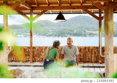 海辺の足湯で語らう老夫婦 【撮影協力：隠岐シーサイドリゾートみやび様】 135093391
