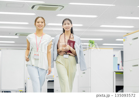 オフィスで歩きながら話す女性 オフィスで歩きながら話す女性 135093572
