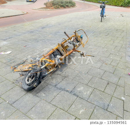 Burned Electric Scooter Wreck on Urban Sidewalk 135094561
