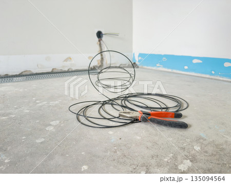 Pliers and Electrical Cable on Floor During Home Renovation 135094564