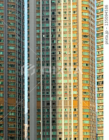 Rows of identical apartment buildings with many windows under the bright sun Rows of identical apartment buildings with many windows under the bright sun 135094586