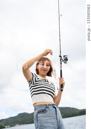 釣り上げた魚を笑顔で見せる女性 【撮影協力:隠岐シーサイドリゾートみやび様】 釣り上げた魚を笑顔で見せる女性 【撮影協力:隠岐シーサイドリゾートみやび様】 135095063