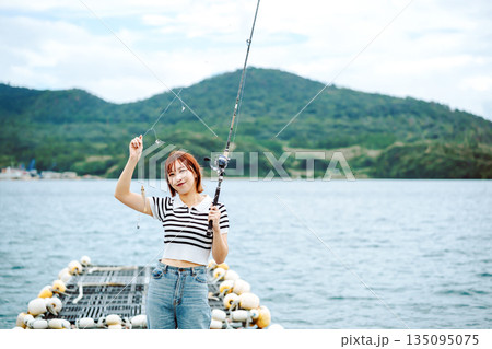海辺で釣りを楽しむ女性 【撮影協力：隠岐シーサイドリゾートみやび様】 135095075