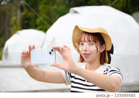 ドーム型テント前で自撮りする女性 【撮影協力：隠岐シーサイドリゾートみやび様】 135095085