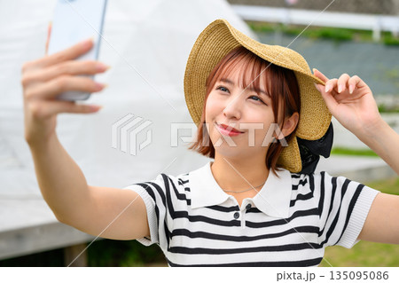麦わら帽子で自撮りする女性 【撮影協力：隠岐シーサイドリゾートみやび様】 135095086
