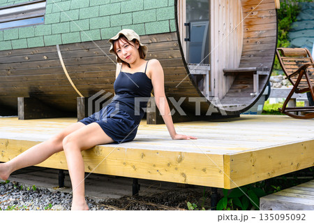 女性がサウナ小屋のデッキに座る 【撮影協力：隠岐シーサイドリゾートみやび様】 135095092